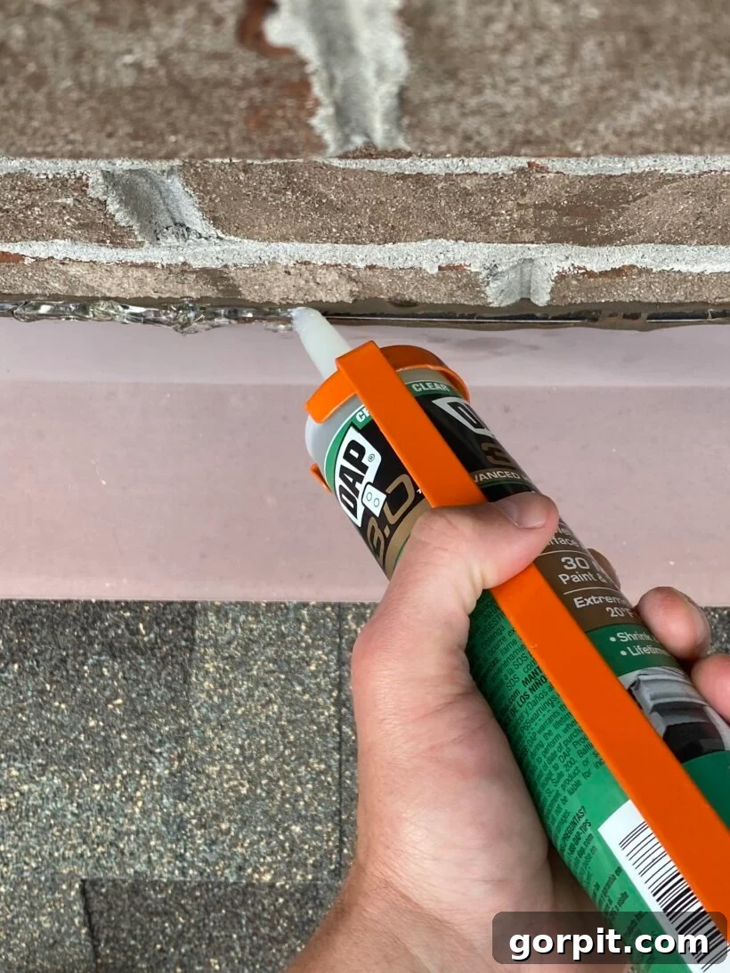 Applying caulk to roof flashing to seal a gap