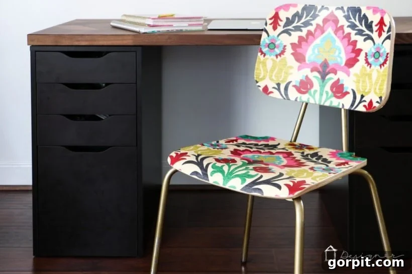 Close-up of a beautifully decoupaged wood chair with patterned fabric, positioned in a home office setting.