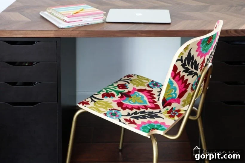 A decoupaged wood chair with vibrant fabric detail, highlighting how to achieve an "upholstered" look on a budget.