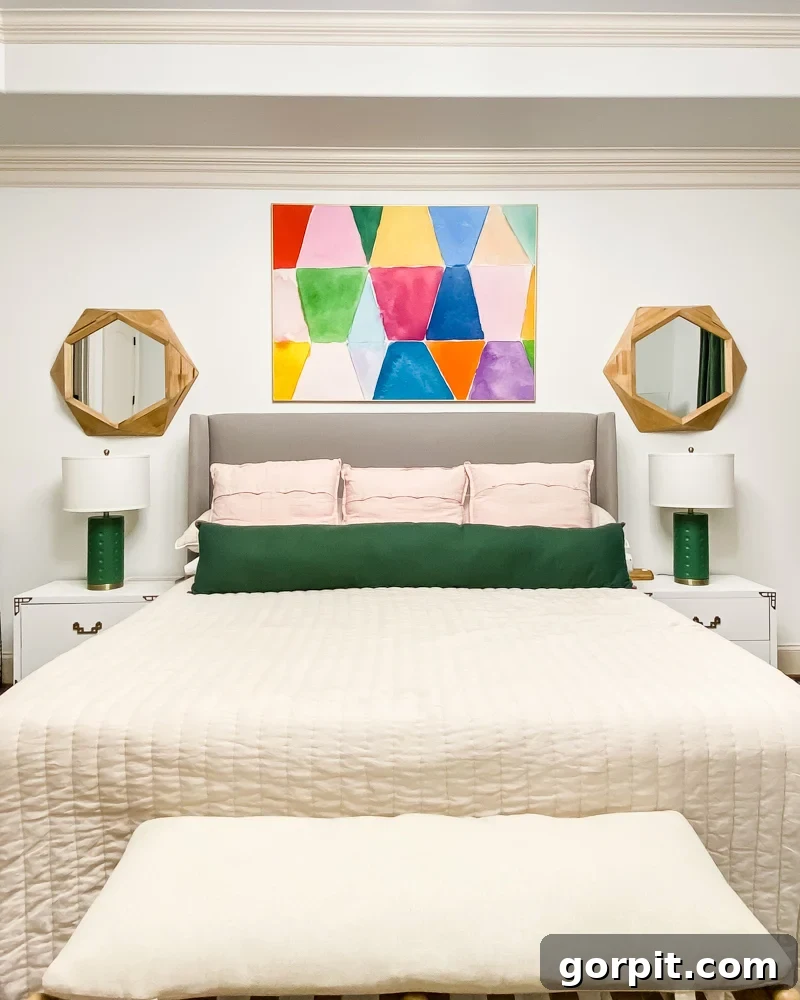 bedroom with colorful art, lamps, and bedding and white bedside tables