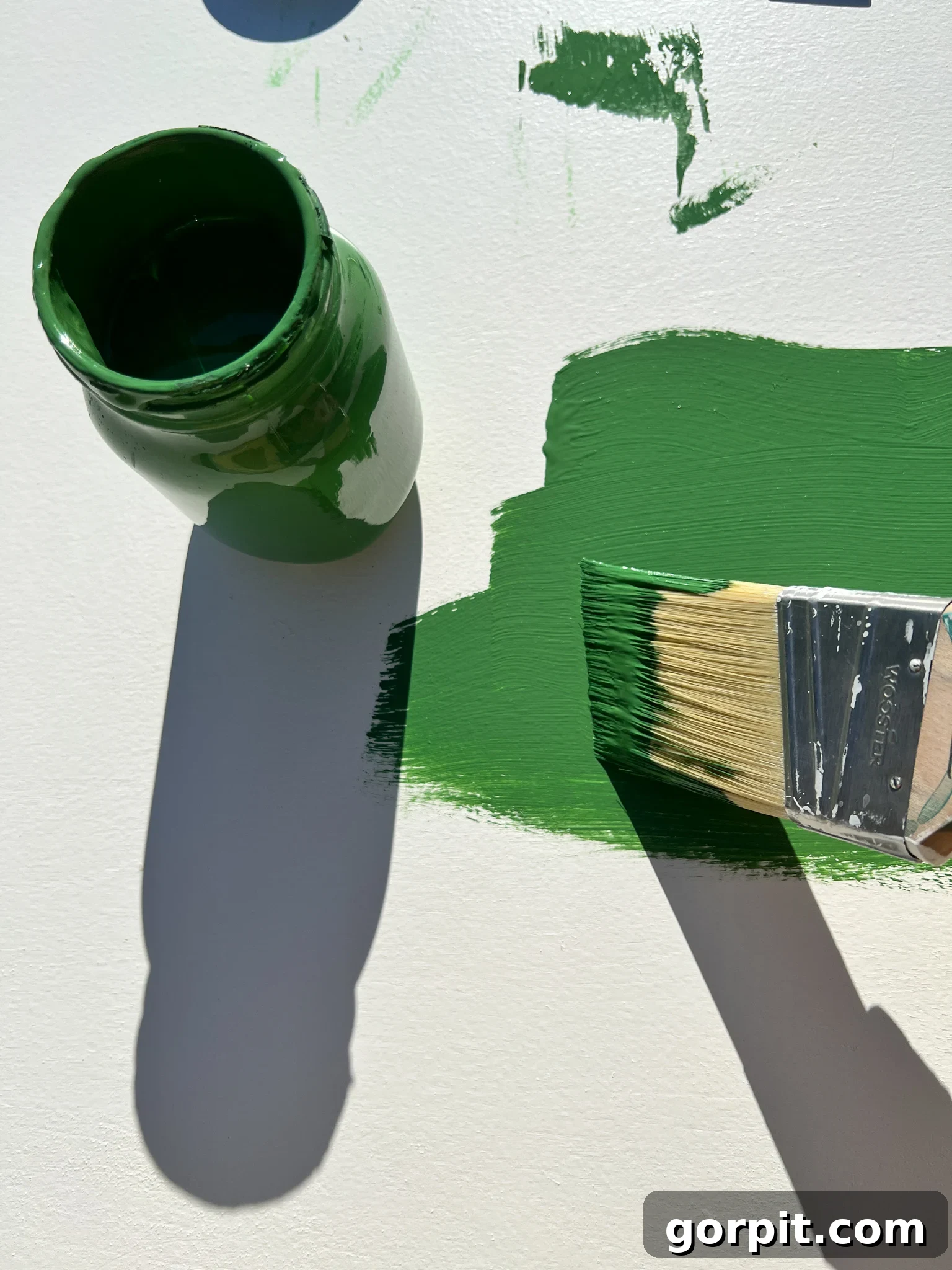 Plywood being painted green as the base for the light-up wall art.