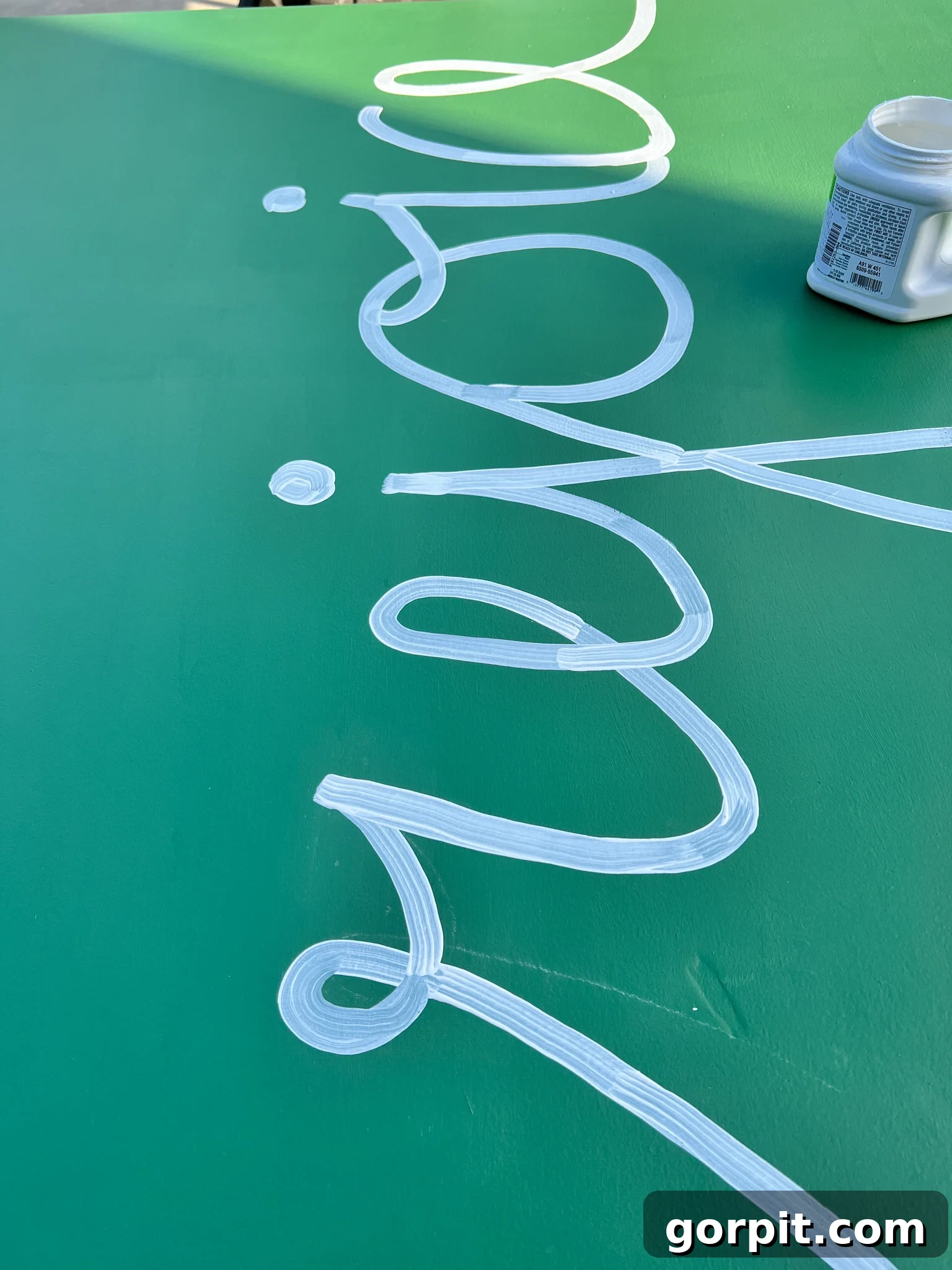 The word 'Rejoice' partially painted in white over the green background.