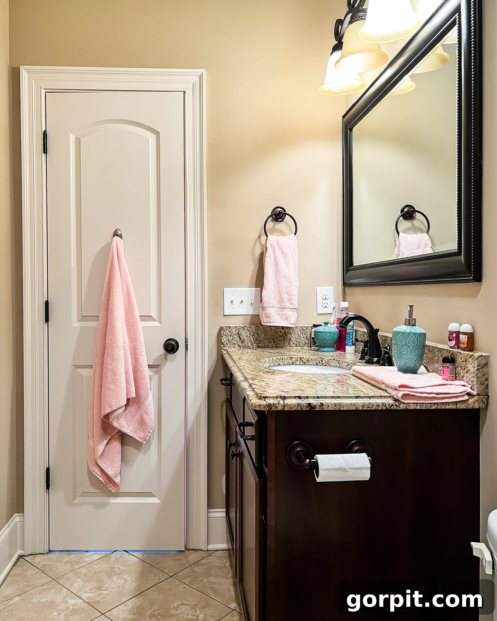 The "before" picture of an outdated bathroom with brown walls and dark wood vanity with beige walls. Paint is essential when doing a bathroom makeover on a budget.