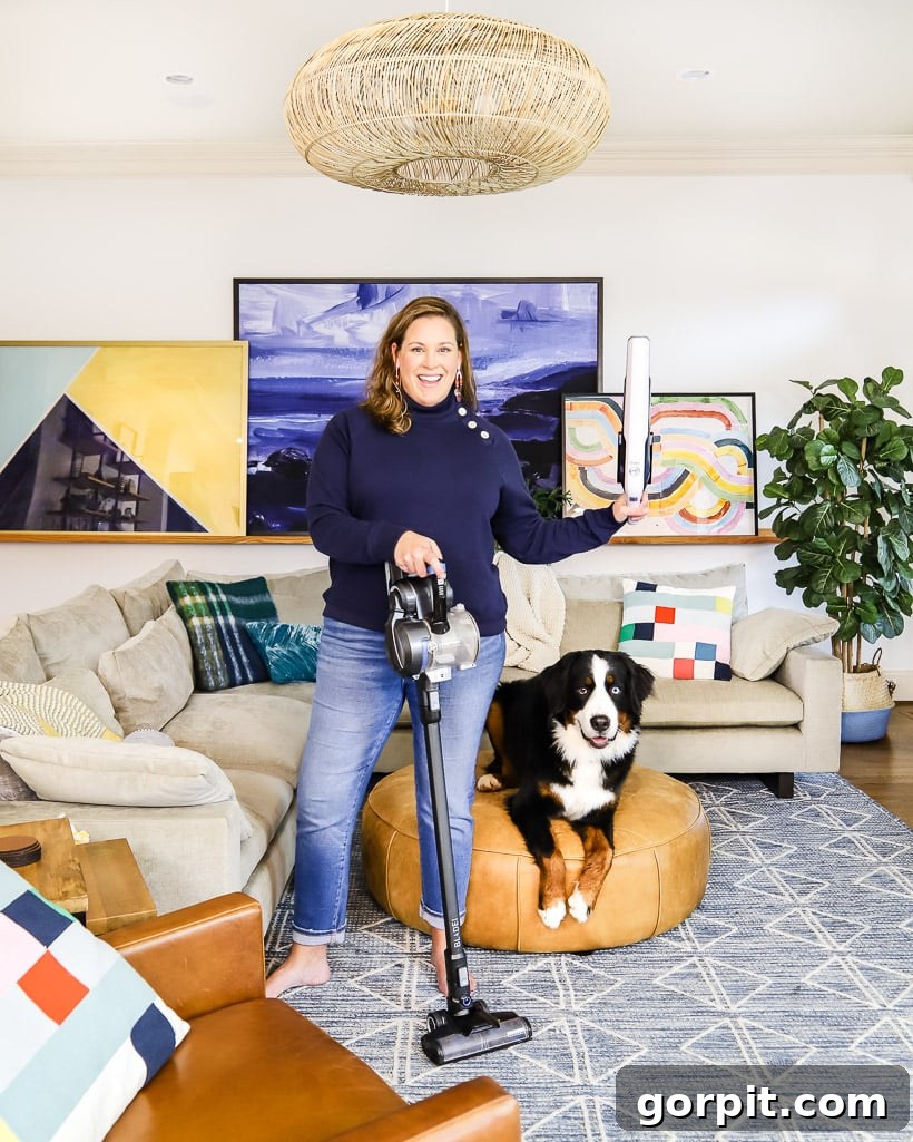 Secrets to a Clean Home with Dogs 3 Woman using a cordless vacuum cleaner next to her Bernese Mountain Dog, demonstrating easy daily cleaning.