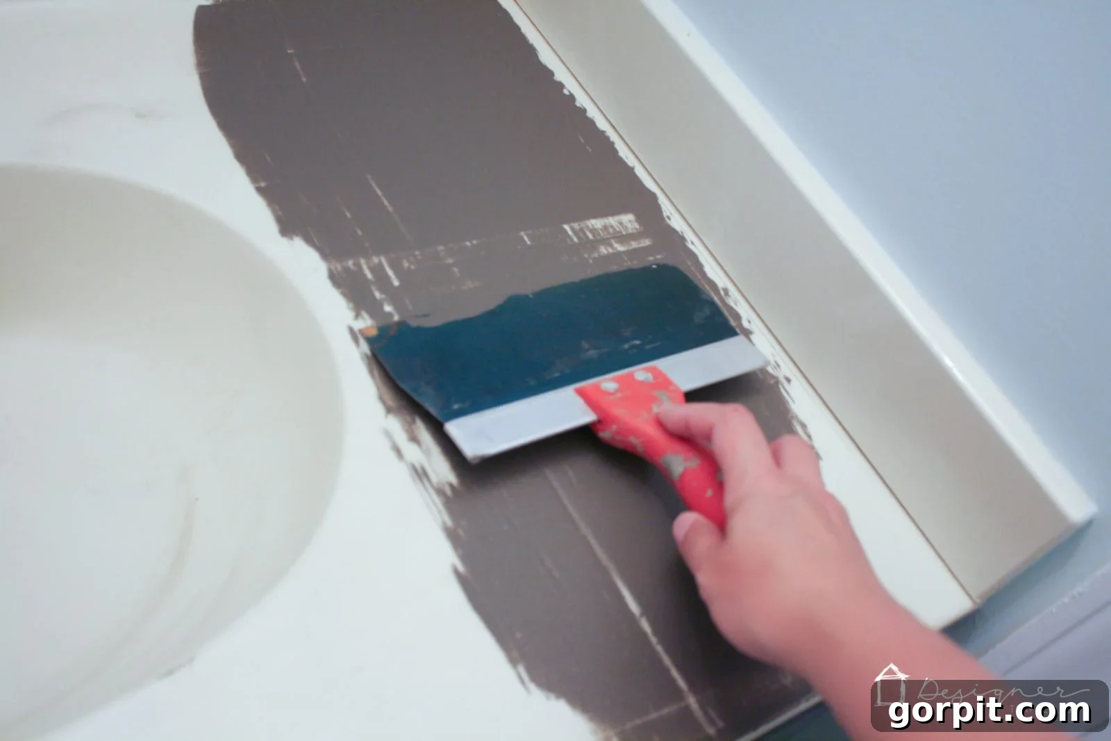 Applying the first thin coat of concrete overlay to a bathroom vanity