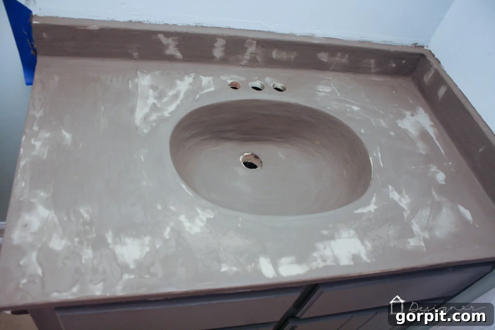 Splotchy appearance of the second coat of concrete overlay drying on a vanity