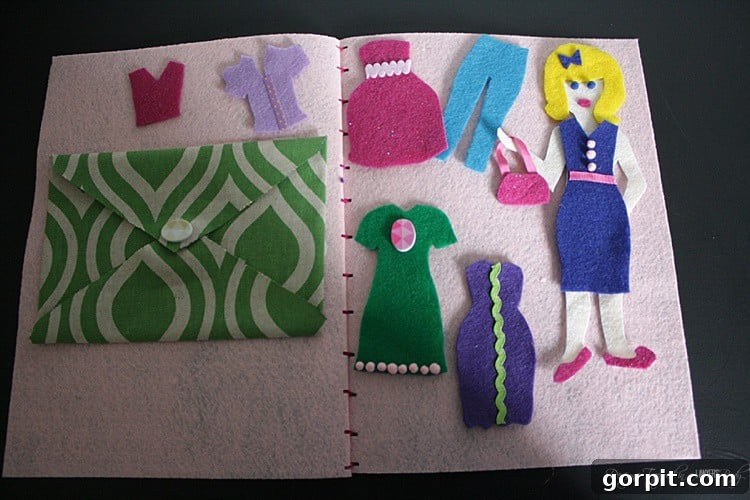 A completed DIY felt dress-up doll lying on its open felt book, surrounded by various colorful outfits and accessories, ready for play.