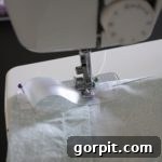 Upcycle Sheets into Chic Curtains 7 GENIUS! Learn how to make curtains out of sheets! Full tutorial by Designer Trapped in a Lawyer's Body. Final sewing step for back-tab curtains.