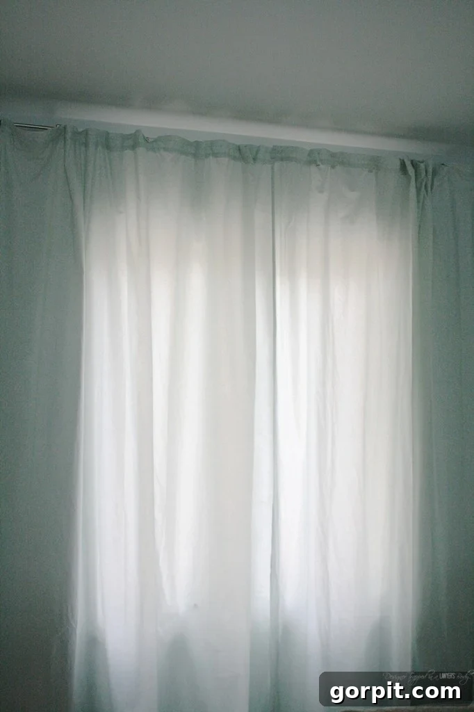 Upcycle Sheets into Chic Curtains 9 GENIUS! Learn how to make curtains out of sheets! Full tutorial by Designer Trapped in a Lawyer's Body. Elegant DIY sheet curtains in a finished room.
