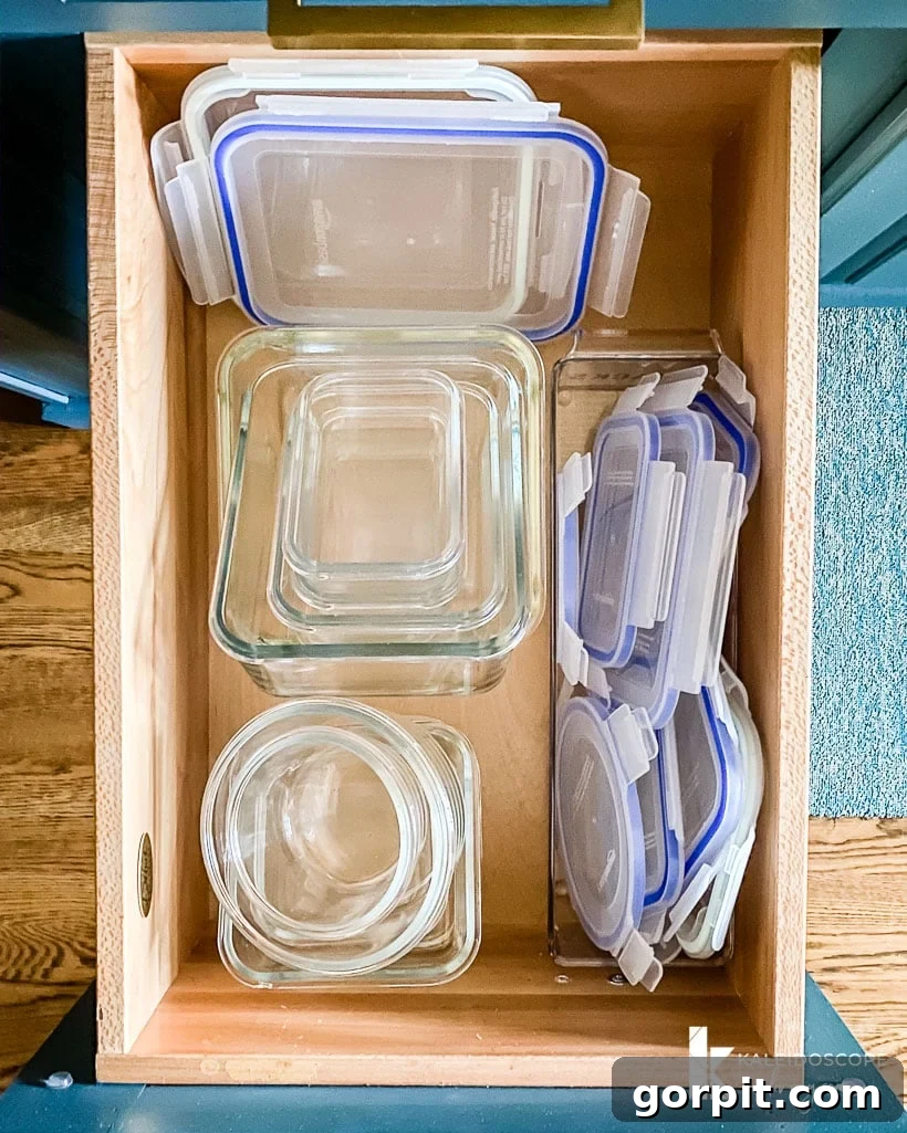 A decluttered kitchen drawer with various food storage containers neatly stacked.