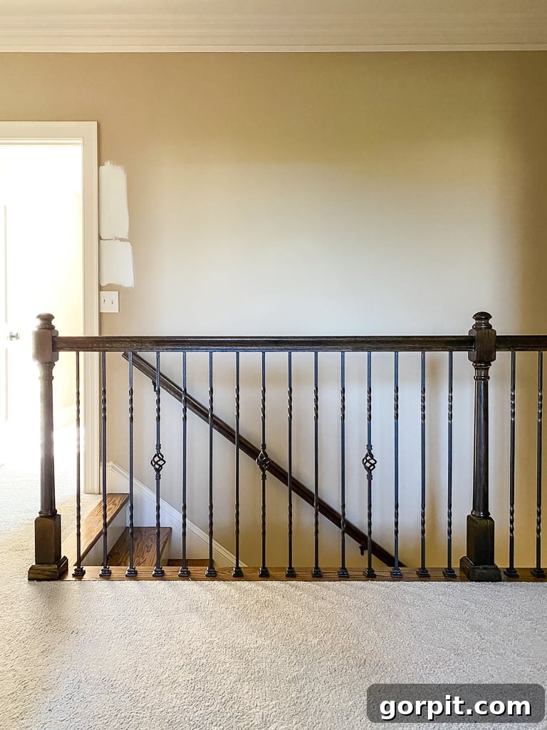 Before photo of the upstairs hallway with an old iron stair railing