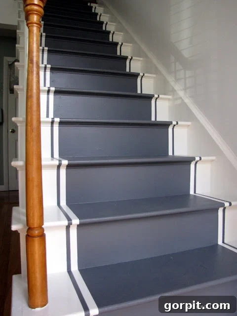 Merdivenlerinizi Şıklaştırın: İlham Veren Koşucu Halı Fikirleri 12 A home's DIY white and grey painted runner on stairs. The tiny corner text reads,