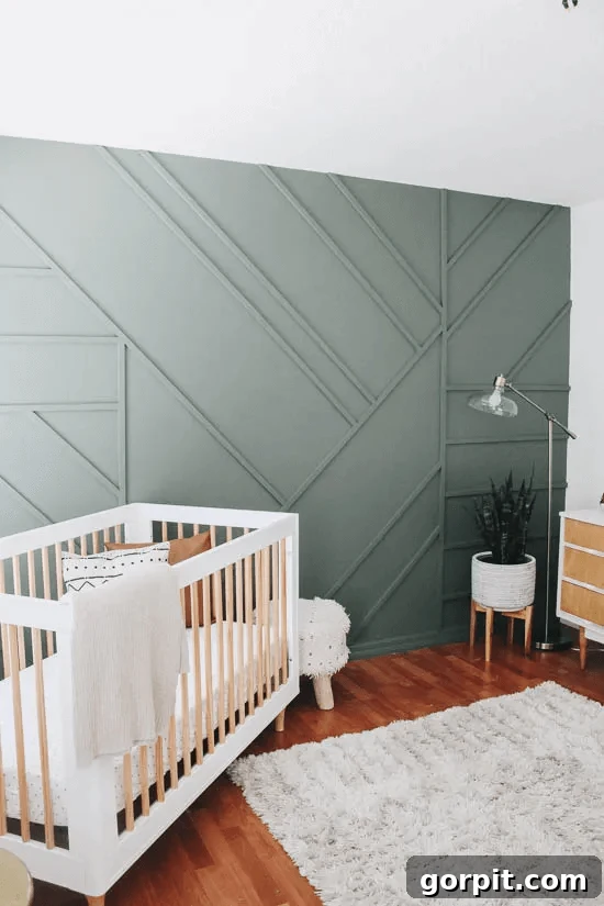 Transform Your Walls with DIY Board and Batten 11 A serene nursery is highlighted by a sage grey accent wall, which features an innovative and visually captivating geometric board and batten pattern, adding a modern and artistic touch to the room.