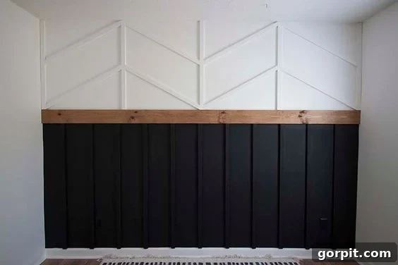 Transform Your Walls with DIY Board and Batten 14 A sophisticated board and batten wall features traditional dark grey vertical boards on the bottom, elegantly topped with a crisp white herringbone pattern, creating a striking two-tone accent.