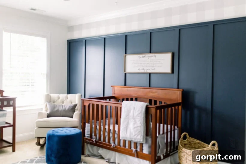 Transform Your Walls with DIY Board and Batten 18 A charming baby’s room features a dark wood crib against an eye-catching navy blue board and batten wall, beautifully contrasted with buffalo plaid wallpaper on the upper section, creating a cozy and stylish retreat.