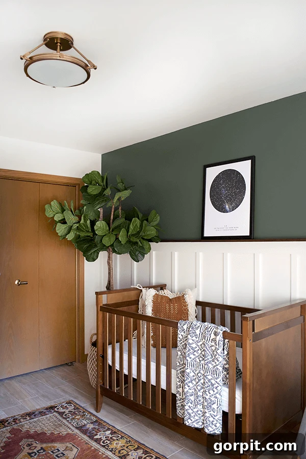 Transform Your Walls with DIY Board and Batten 21 A serene nursery features a dark wood crib set against a pristine white board and batten wall. Above the crib, an olive-green wall includes a poster depicting the night sky, creating a peaceful and imaginative atmosphere.