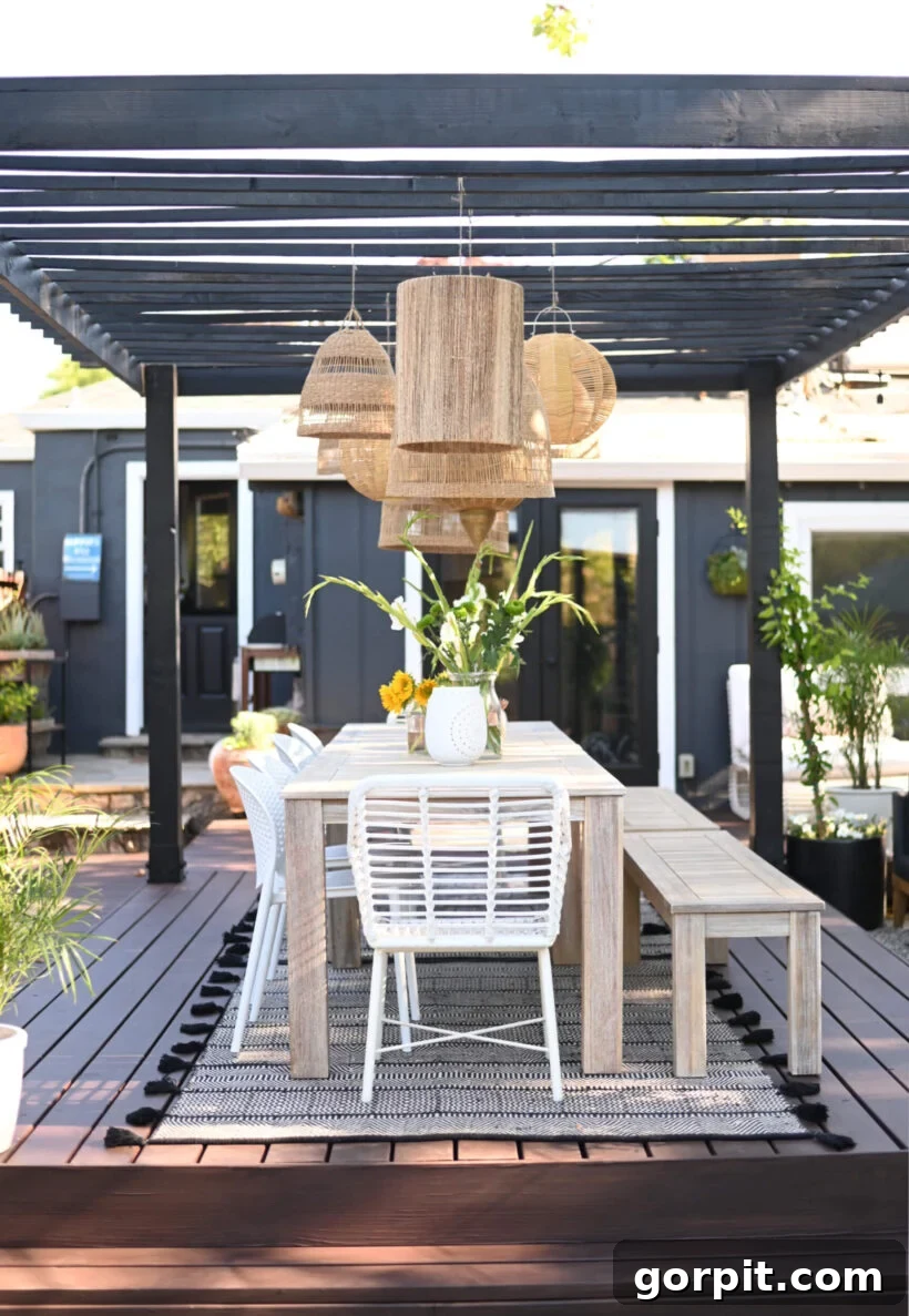 Porch Perfection: Designer Decor and Styling Tips 10 backyard patio with pergola and rattan pendant lights