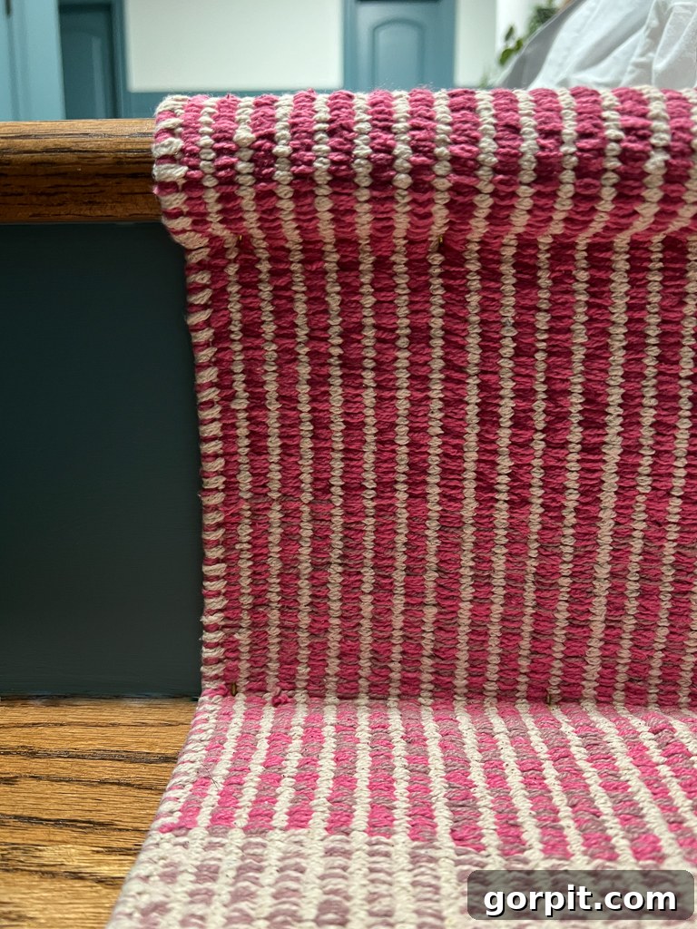 Demonstration of wrapping a stair runner tautly around the bullnose of a stair tread for installation