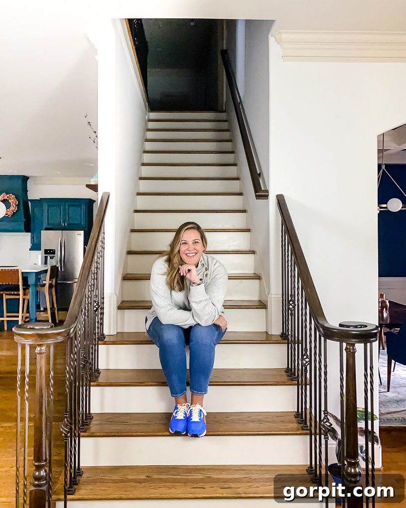 Tasha Agruso sitting on a basic, unadorned staircase before the renovation project