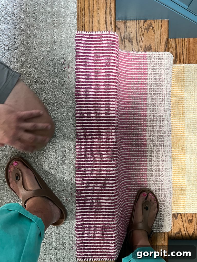 Stapling the top edge of a stair runner into place, showing close-up of staple gun and staple placement