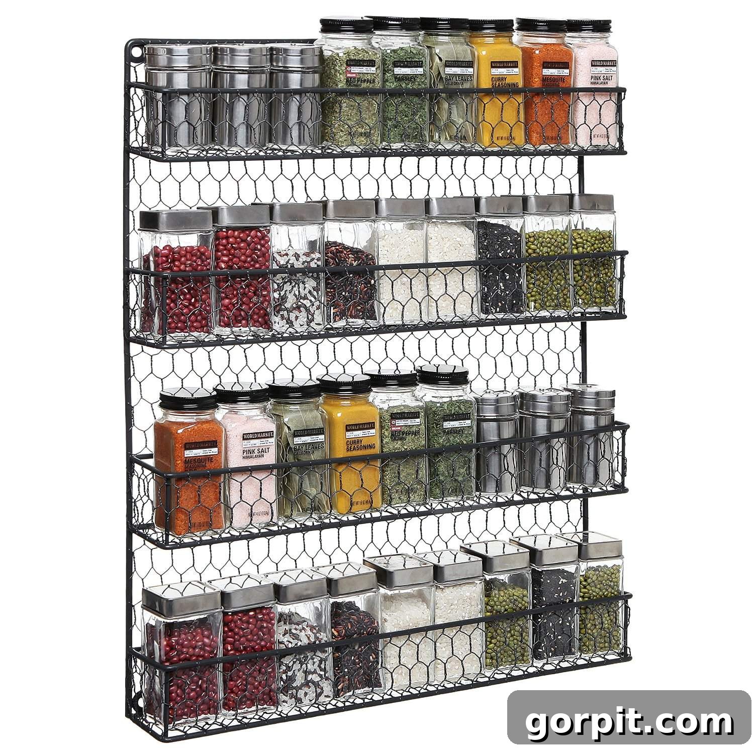 A chicken wire hanging spice rack full of varying spices, both ground and unground against a white background. 