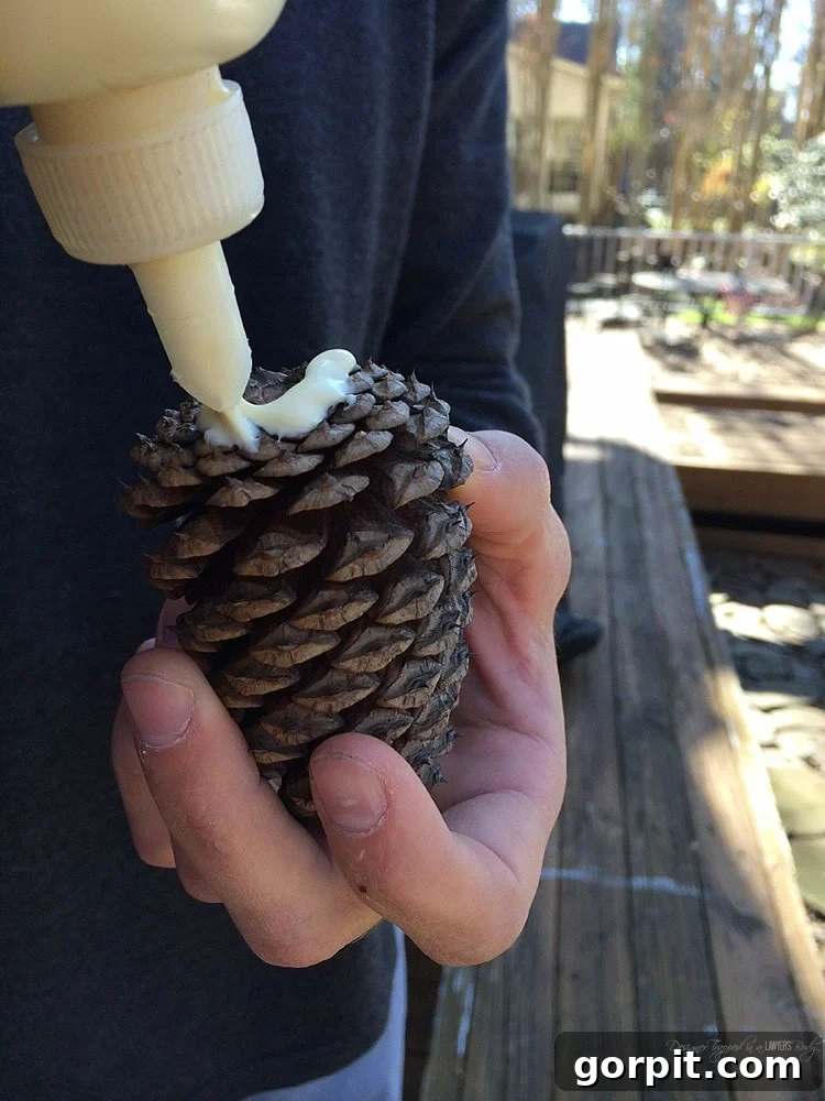gluing pinecone onto log reindeer
