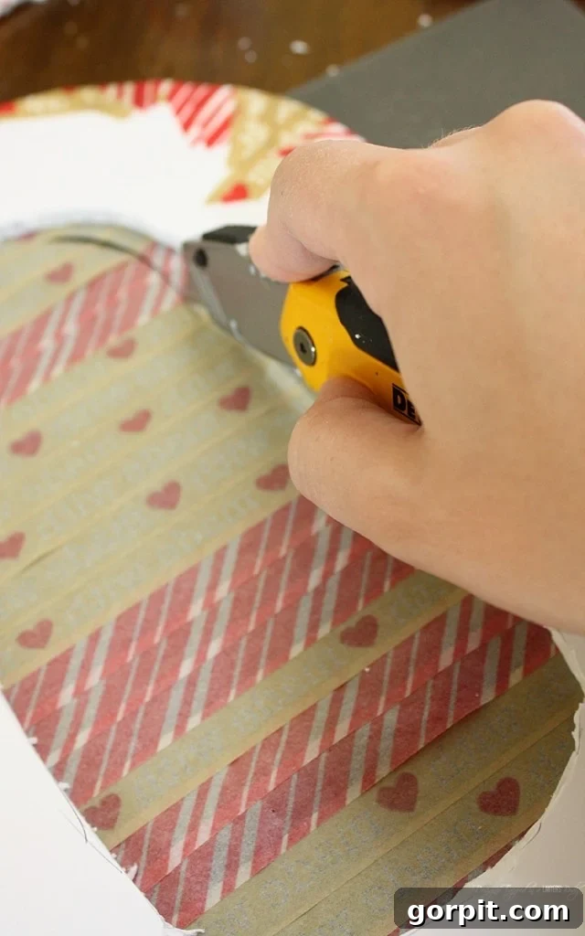 A closer look at the washi tape application, showing how it neatly wraps around the foam core edges, preparing the base for tissue paper embellishment.