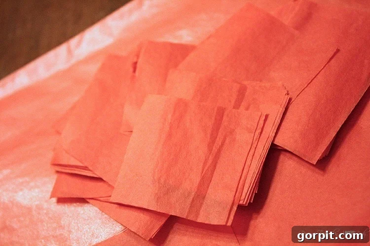 Prepare for the fluffy texture by cutting your tissue paper into 1-inch squares. This step creates the building blocks for your stunning DIY Valentine's wreath.