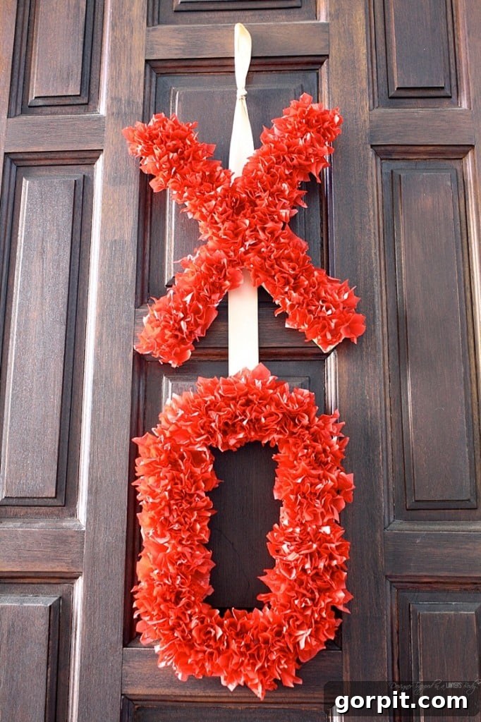 The finished DIY Valentine's Day wreath, a stunning and fluffy 'XOXO' creation made with tissue paper, ready to adorn your home with love.