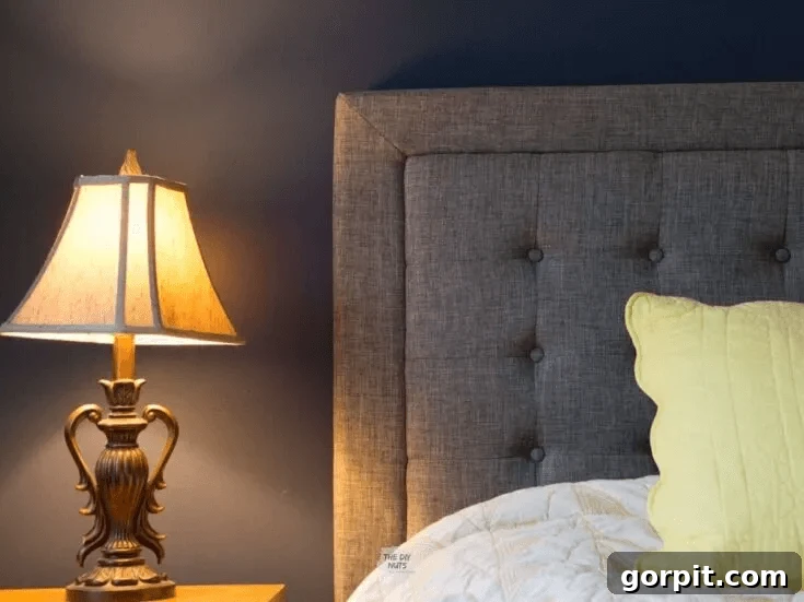 navy bedroom walls with upholstered gray headboard
