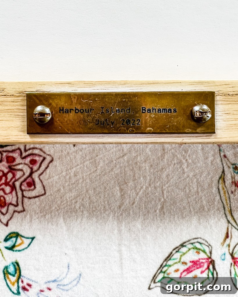 Close-up of a custom framed panoramic photo featuring a brass plaque from Framebridge, adding a personal and elegant touch to the guest room.