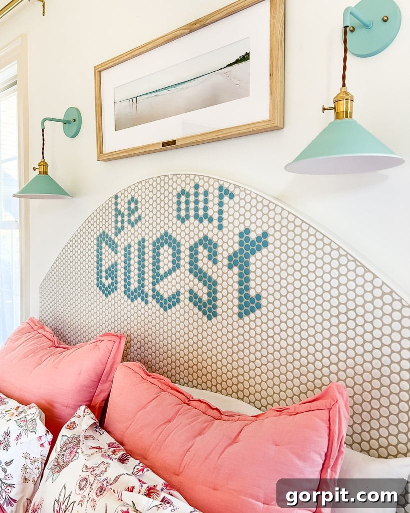 A beautifully decorated guest room featuring a unique DIY tile headboard with a customizable message that reads 'Be Our Guest,' surrounded by inviting decor.