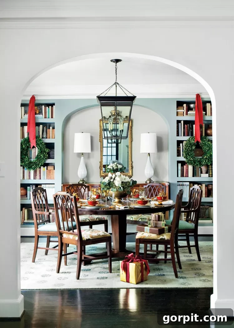 Dining room featuring Christmas wreaths suspended from ribbon in front of built-in bookcases, creating a unique and elegant festive display.