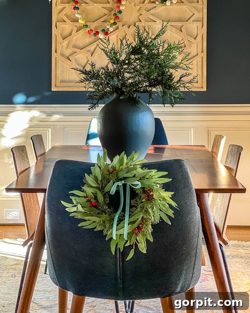 Dining room chairs decorated with elegant mini wreaths for Christmas, showcasing a festive touch by Tasha Agruso of Kaleidoscope Living.