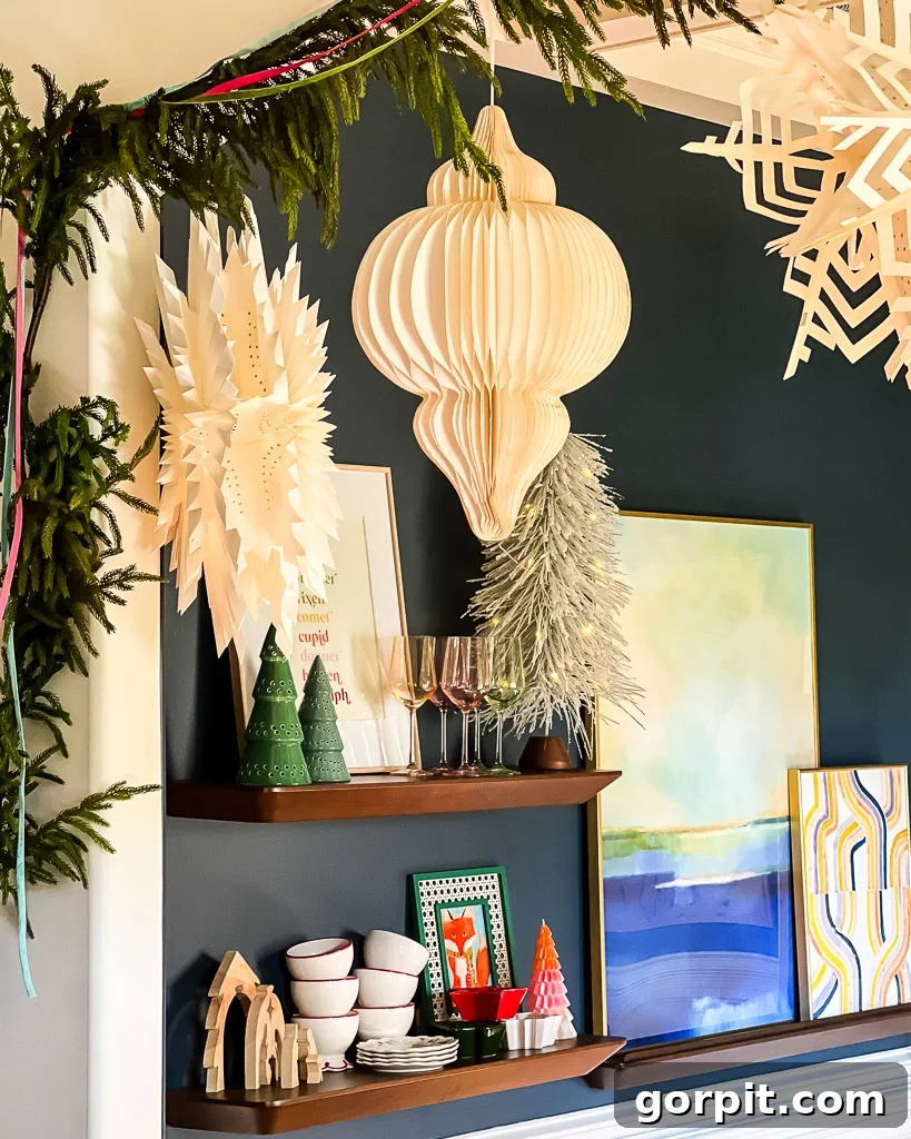 Dining room decorated for Christmas, featuring festive paper lanterns and a display of elegant holiday glassware, styled by Tasha Agruso of Kaleidoscope Living.