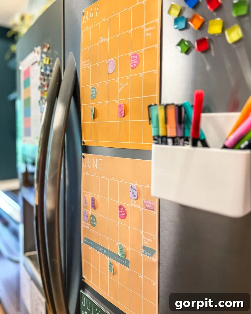 Family Calendar Secrets for a Stress-Free Home 3 colorful family calendar from Kaleidoscope Living hanging on refrigerator, displaying multiple months at once