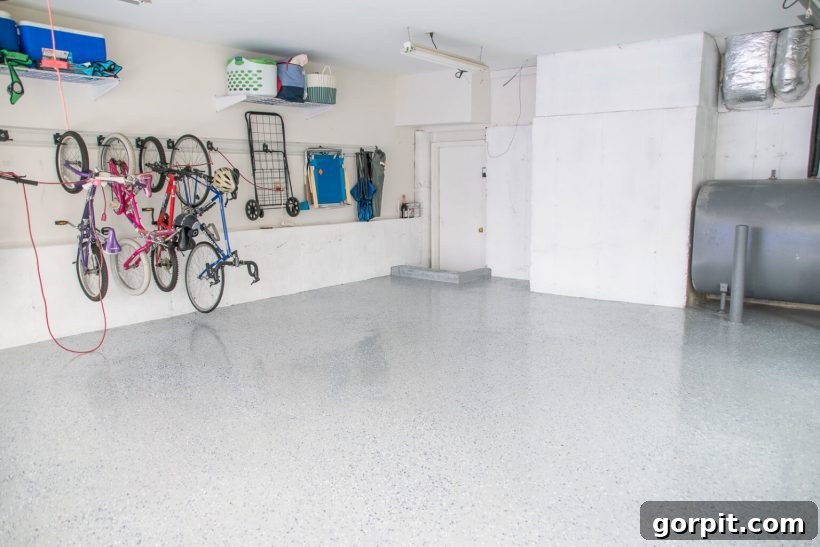 Elevate Your Garage: Smart Flooring Choices 4 A garage floor coated with RockSolid epoxy, showing a smooth, glossy finish with decorative flakes for enhanced durability and aesthetics, creating a professional workshop feel.