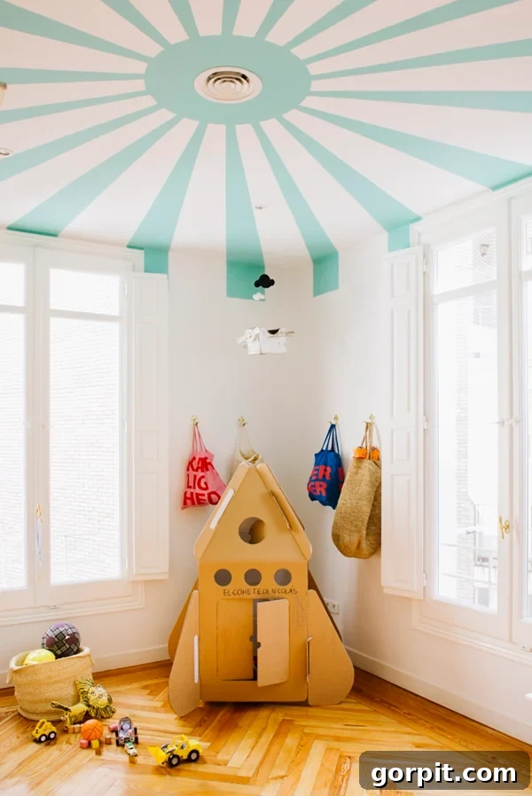 One playroom idea shows a ceiling made to look like a circus tent, along with a cardboard rocket ship and bags in the corner. 