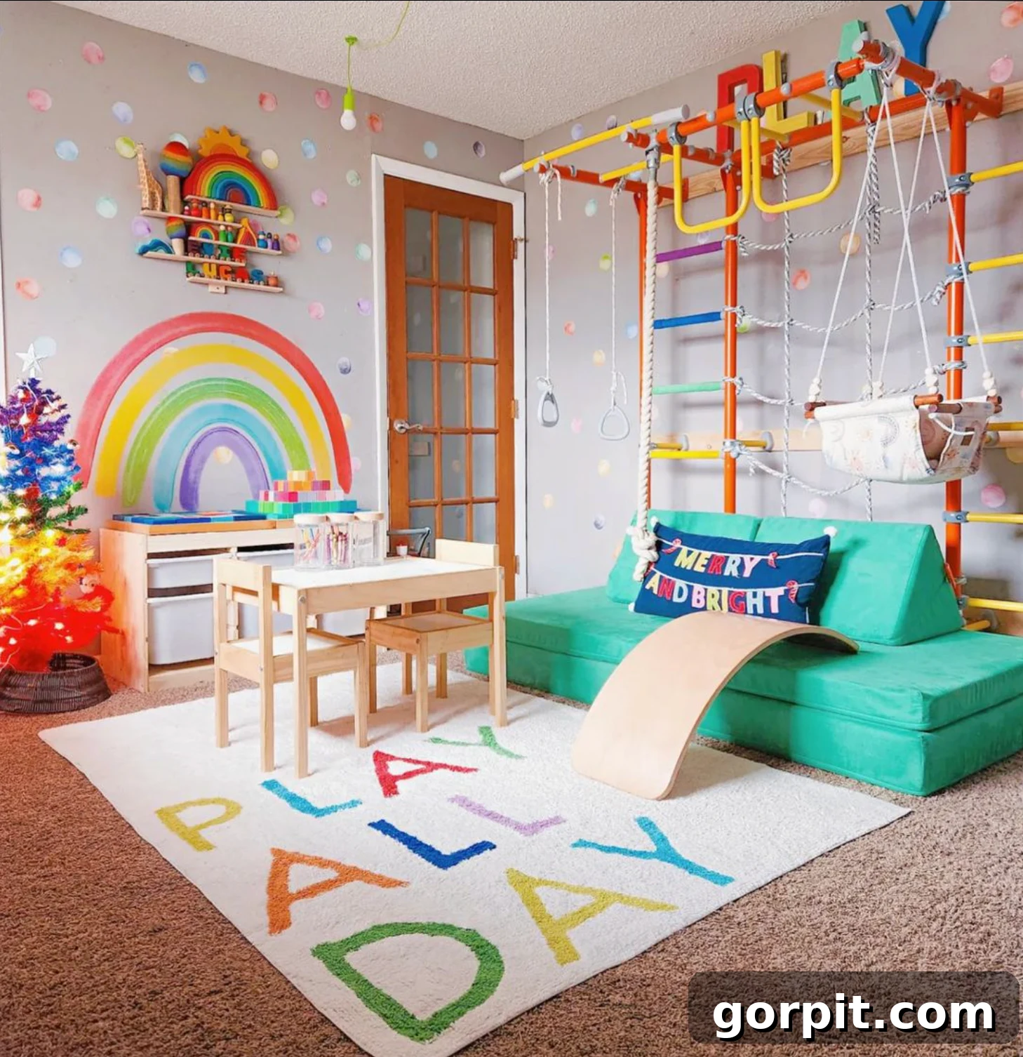 A colorful indoor gym and playroom for young children includes a play table, storage bins, and a green couch. The rug says "Play all day."