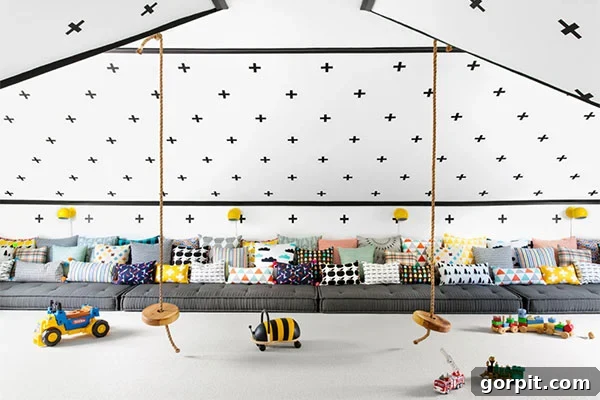 Playroom ideas for attics with angled ceilings include black crosses along the wall and ceiling, cushions on the floor for seating, and two hanging rope swings. 