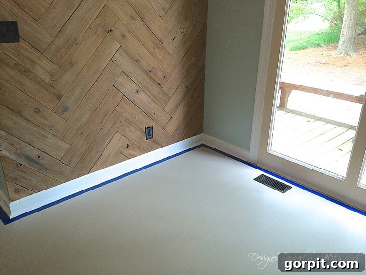 We started by taping off the perimeter of our room with 1 inch painter's tape.  This was a personal choice.  You can run your stencil all the way up to your baseboards if you choose.