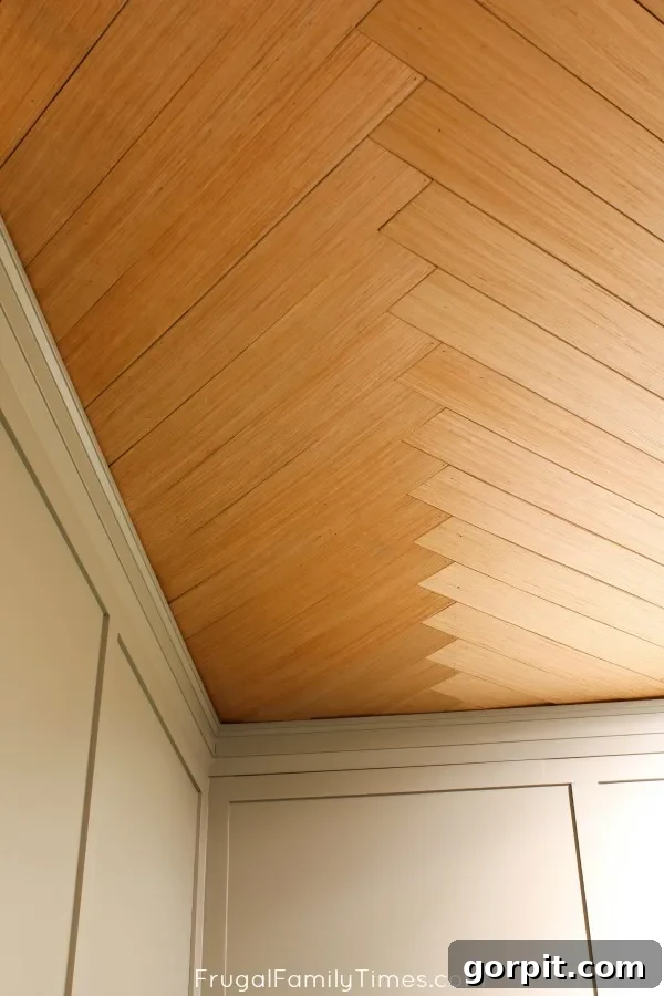 Basement ceiling featuring a DIY herringbone pattern made from plywood, creating a sophisticated and eye-catching geometric design.