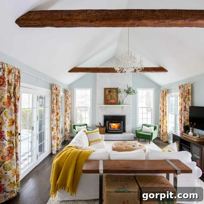 Living room featuring a vaulted ceiling adorned with decorative faux wood beams, creating a warm, rustic aesthetic and adding visual interest to the expansive space.