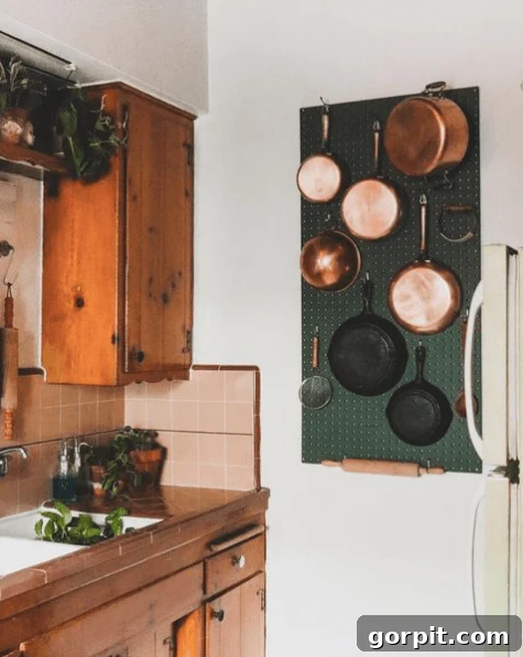 Smart DIY Storage Hacks for Compact Living 3 dark green peg board with copper and cast iron pots and pans