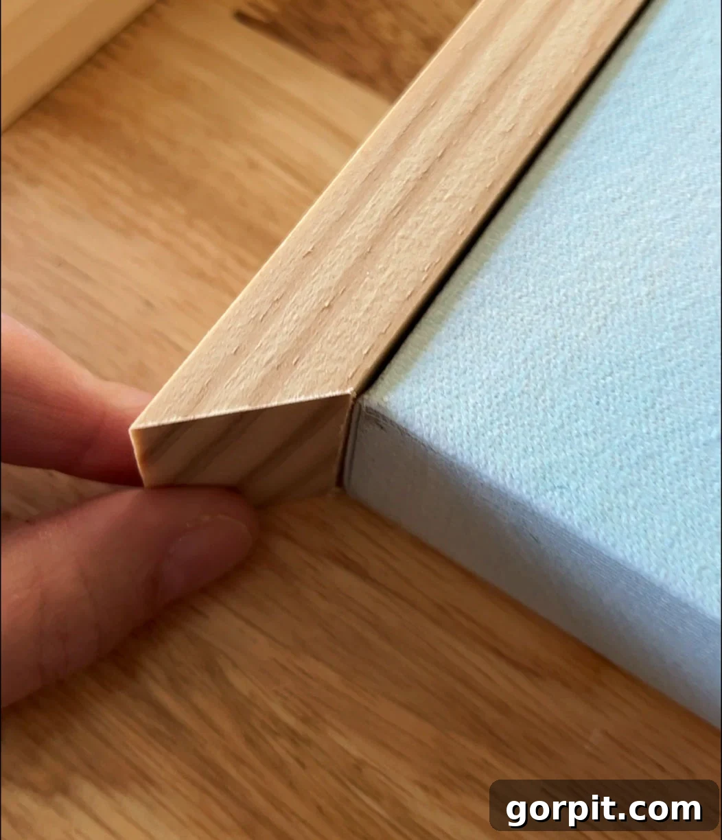 Close-up of a mitered corner of a flush mount DIY canvas frame being assembled, showing precise fit