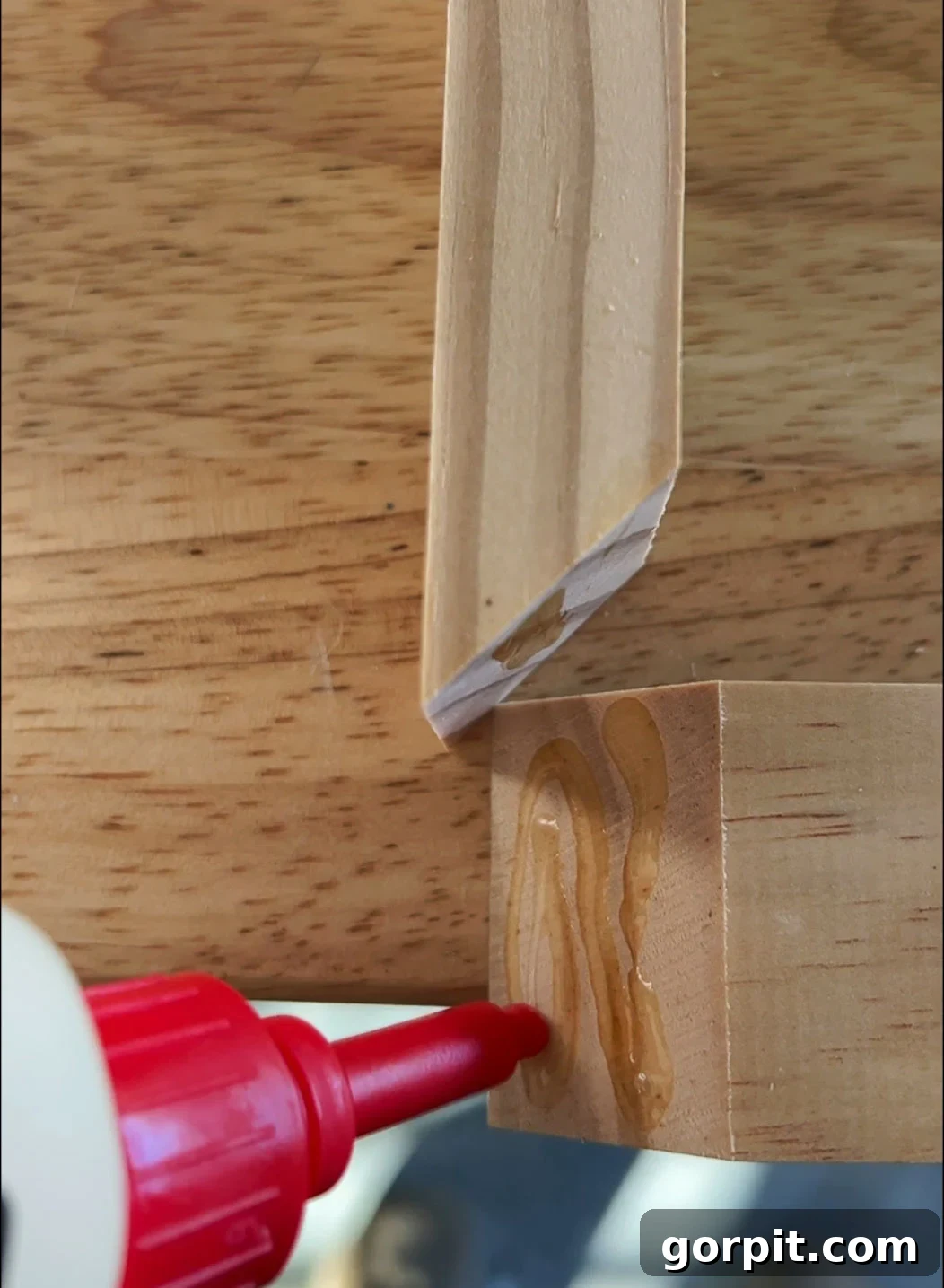 Effortless Budget DIY Canvas Frame 8 Applying DAP Weldwood Instant Adhesive to mitered corners of DIY canvas frame for strong, fast bond