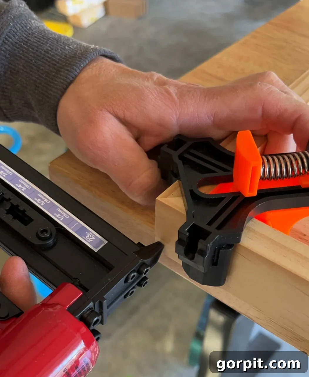 Nailing corners of a DIY canvas frame together with a pin nailer for added strength and durability