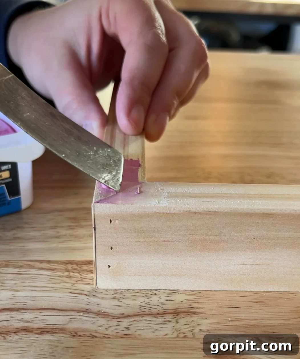 Using DAP Plastic Wood-X to fill nail holes and imperfections in a DIY canvas frame before staining