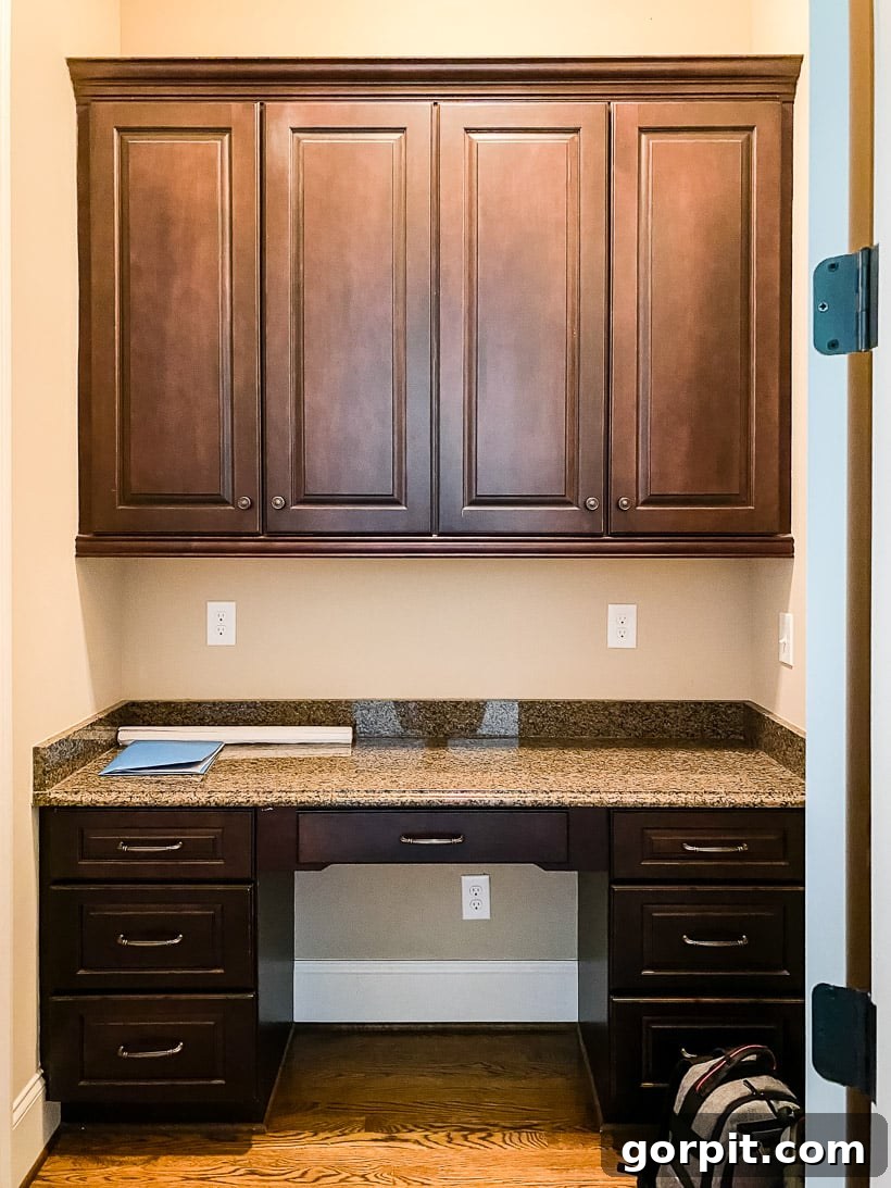 Built-in office area as it looked when the family moved in, featuring original cabinets and granite countertops.