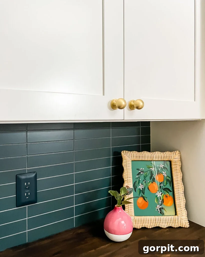 Modern stacked kitchen backsplash with navy blue tiles, white cabinets, and wood countertops, showcasing the finished DIY installation.